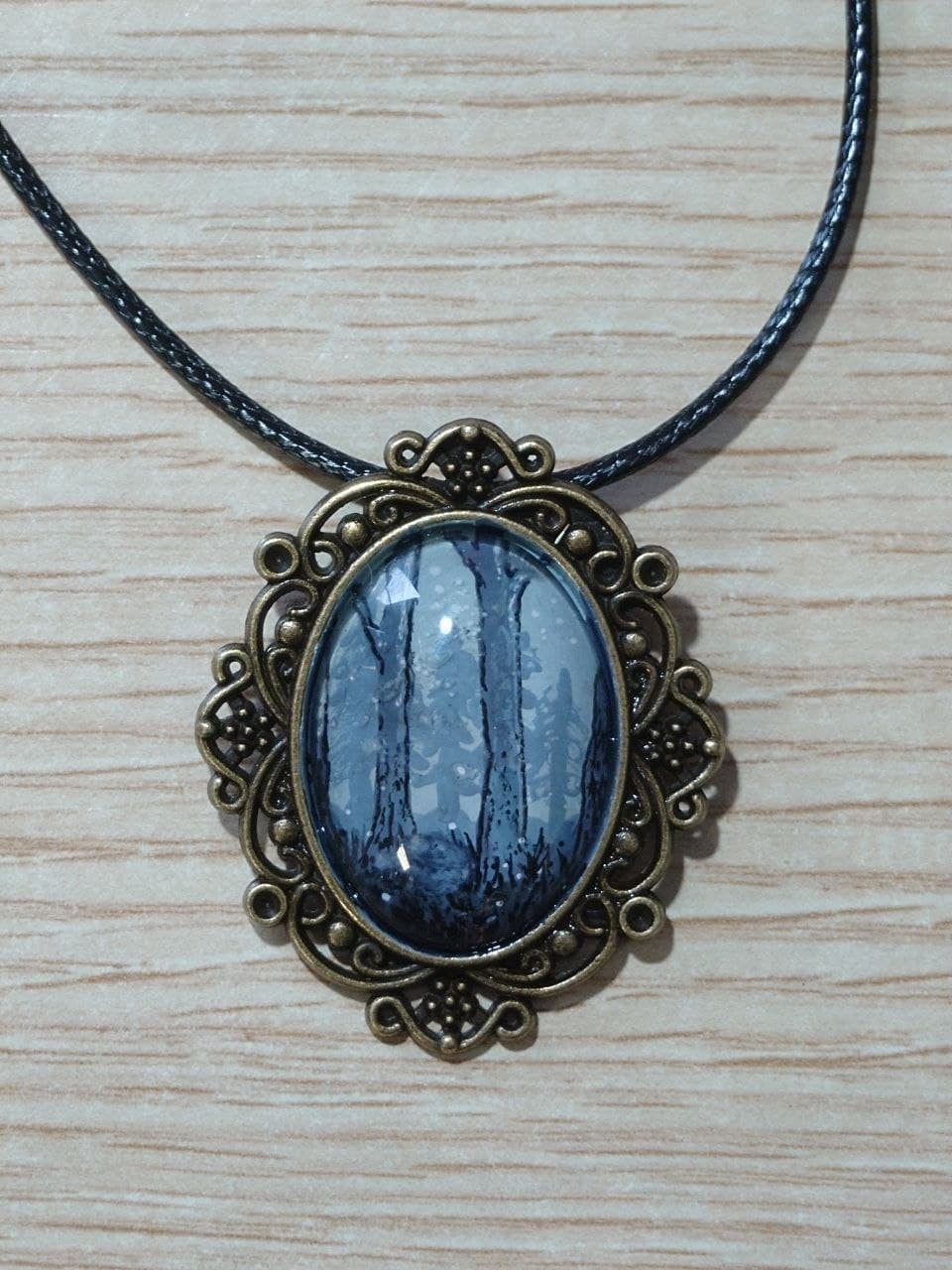 Collar artesanal con escena de bosque gris y marco en bronce